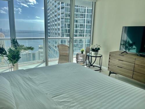 迈阿密Sun&Sea IconBrickell Unit的一间卧室设有一张大床和大窗户