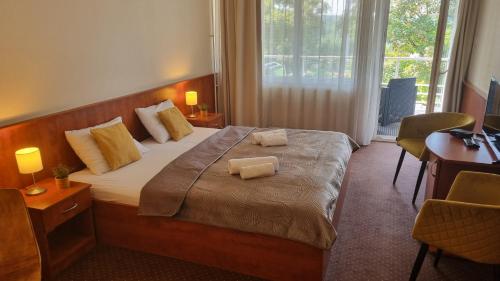 塔塔班亚Sport Hotel的一间卧室配有一张床,上面有两条毛巾