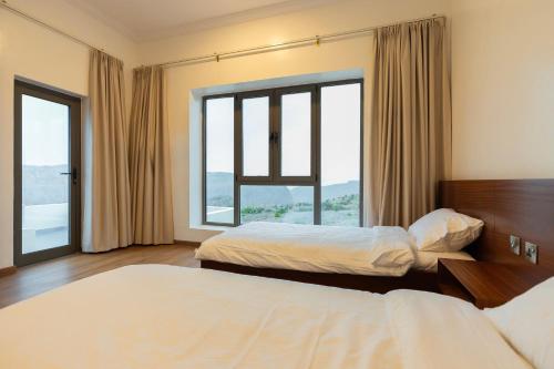 QurayyahHorizon Villa的酒店客房设有两张床和大窗户。