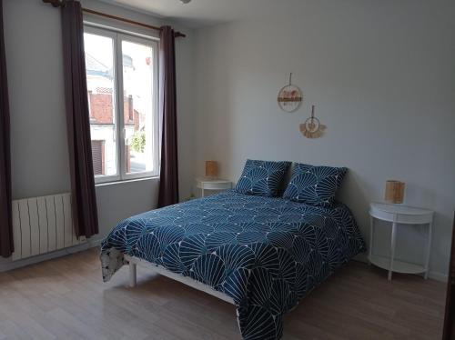 阿尔贝AU CELICT的一间卧室配有一张带蓝色棉被的床和窗户。
