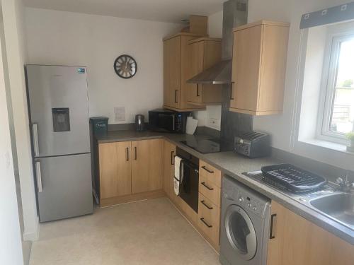 新港Contemporary Coach House in Newport, Isle of Wight的厨房配有冰箱和洗衣机。