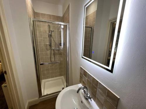 梅尔顿莫布雷The Burley at Scalford House的浴室配有盥洗盆和带镜子的淋浴