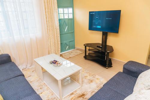 EmbuHaven Air BnB Embu的客厅配有蓝色的沙发和电视