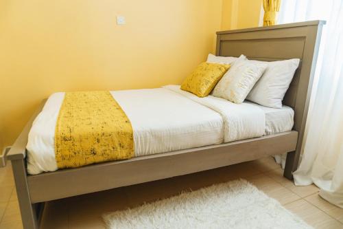 EmbuHaven Air BnB Embu的一张带黄色毯子和枕头的床