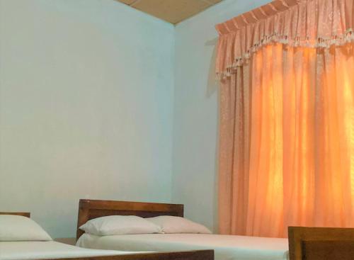 阿努拉德普勒Grand Refuge Romantic dinner & Bikes的一间卧室配有两张床和橙色窗帘