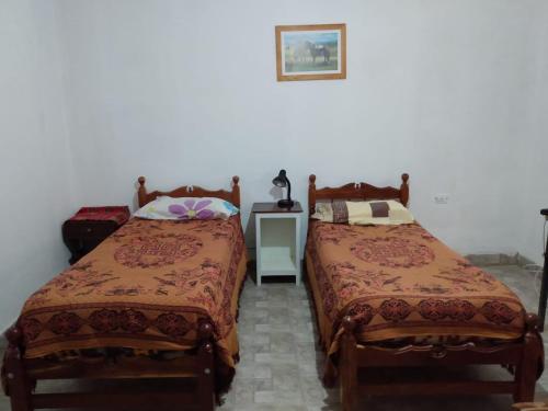 乌玛瓦卡Hostal El Farolito的两张睡床彼此相邻,位于一个房间里
