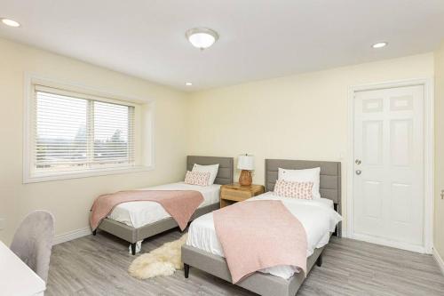 温哥华Home near Downtown Vancouver East@ Joyce Skytrain的一间卧室设有两张床和窗户。