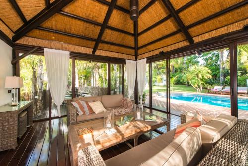 马贝拉Villa in a palm tree plantation的开放式客厅,后面设有游泳池