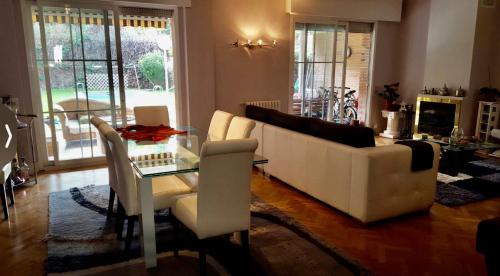 马德里Casa de Mirtha的客厅配有白色沙发和玻璃桌
