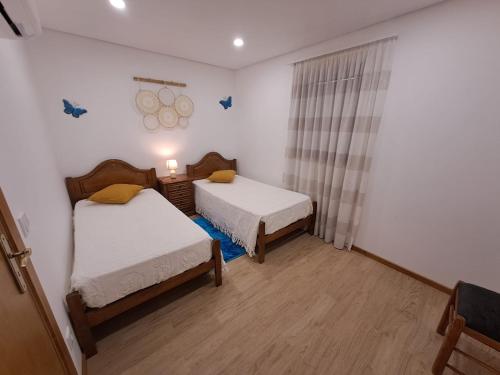 恩特雷里奥斯Burguesinha AL Entre-os-Rios的一间设有两张床的房间和一个窗户