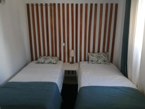 珀彻斯Retiro dos sonhos的带条纹墙的客房内的两张单人床