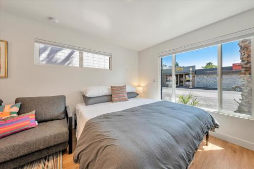 圣卡洛斯Silicon Valley Stay Apartments的一间卧室配有一张床、一张沙发和一个窗口