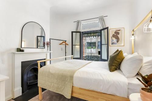 悉尼Surry Hills l 2 Bedroom Terrace Home的一间卧室配有一张床和一个壁炉