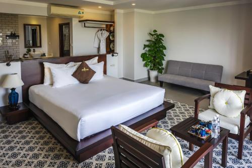 会安Hoi An Odyssey Hotel & Spa的一间卧室设有一张床和一间客厅。