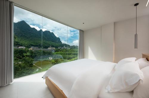 张家界张家界虚度·ANNICA旅游度假酒店的一间卧室设有一张床和一个大窗户