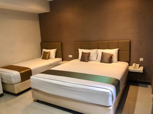 泗水卡纳次特拉宾馆的一间酒店客房,房间内设有两张床
