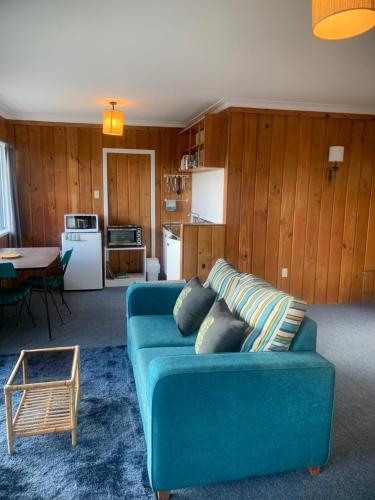 派西亚隅趣旅舍的客厅配有蓝色的沙发和桌子
