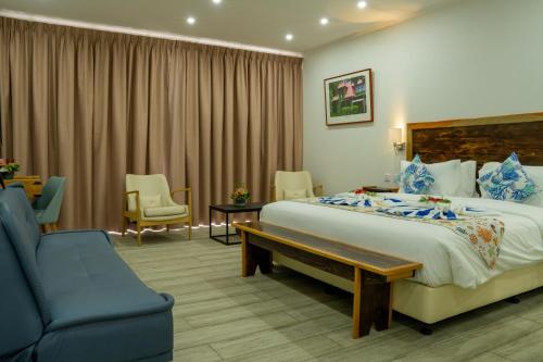 博瓦隆Lakaz Kreol的酒店客房,配有一张床和一张蓝色椅子