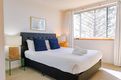 巴利纳美景公寓酒店的一间卧室配有一张带蓝色枕头的床和一扇窗户。