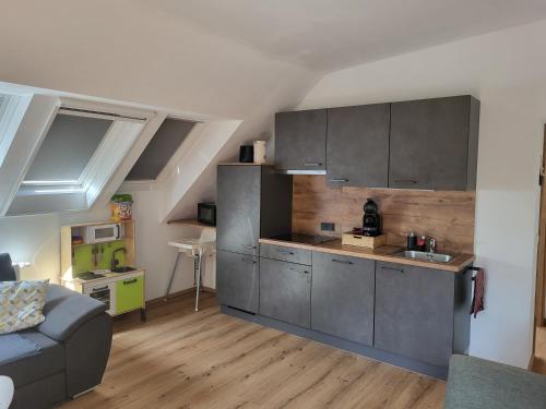 萨尔茨堡Apartments Brunnmeisterhof的一间厨房,内设灰色的橱柜和一张沙发