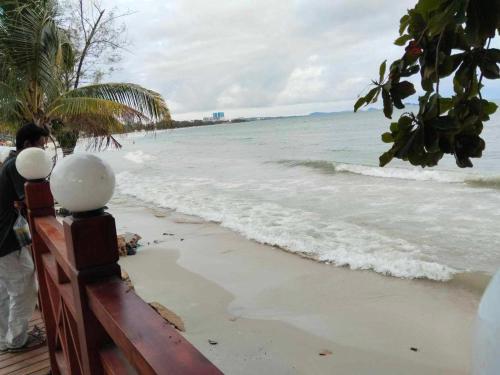 西哈努克Sea Inn Guesthouse Sihanoukville的站在海滩上看海洋的人