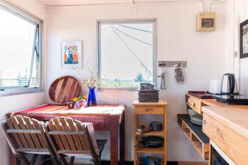 哈士汀FreeFall Hut的厨房配有桌子和两把椅子,设有窗户。