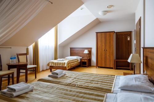 谢米亚蒂切Hotel Kresowiak的酒店客房设有两张床和一张桌子。