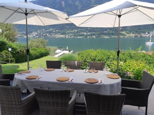 安嫩海姆Seevilla Lotte Ossiachersee的一张桌子和两把白色遮阳伞,享有湖景