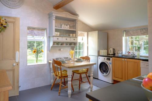切斯特Saughall Mill Farm Cottage的厨房配有桌子和洗衣机。