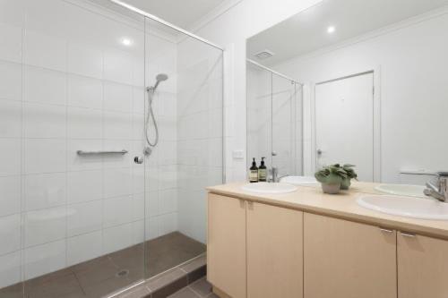 托基Golf Beach Retreat Torquay的带淋浴和盥洗盆的白色浴室