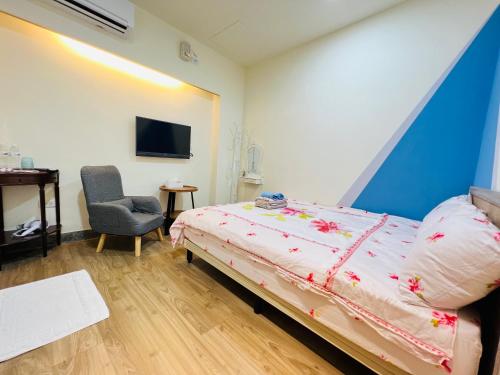 Xingang新港平安民宿的一间卧室配有一张床、一把椅子和电视。
