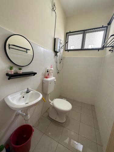 关丹CassaNeyna Homestay Kuantan的一间带水槽、卫生间和镜子的浴室