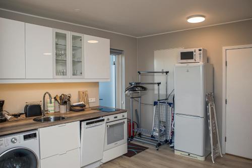 雷克雅未克Cosy modern apartment for up to 4 !的厨房配有白色橱柜和白色冰箱。