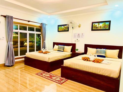 森莫诺隆Chomkatae Bungalows的一间卧室设有两张床和窗户。