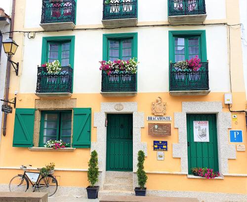 蒙多涅多Casa Bracamonte的建筑的外墙,设有绿门和阳台