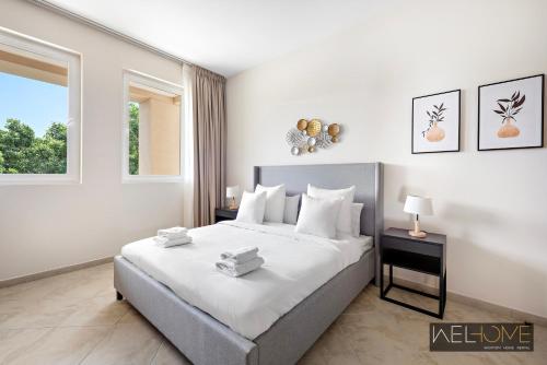 迪拜WelHome - Prime Apartment With Balcony Amidst Lively Area的一间卧室设有一张大床和一个窗户。