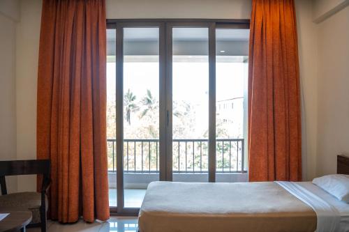 浦那Hotel Dreamland的一间卧室设有一张床和一个大窗户