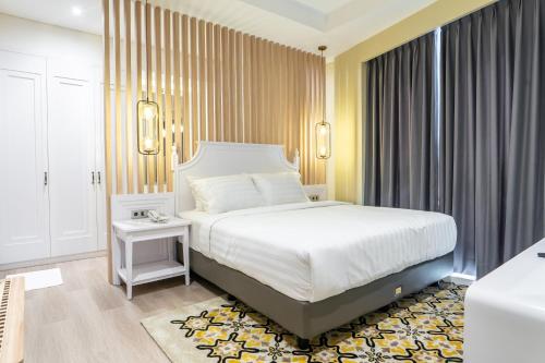 占碑市The Difan Hotel的卧室设有一张白色大床和一扇窗户。