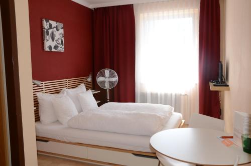 格拉马特诺伊锡德尔HOTEL MARIA的一间卧室设有一张红色墙壁和窗户的床