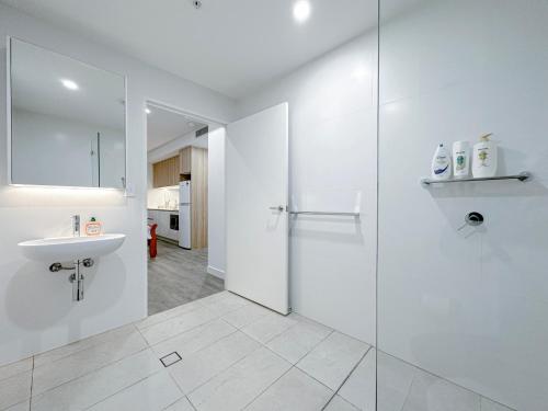 悉尼Burwood Studio的白色的浴室设有水槽和淋浴。