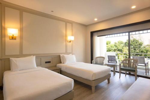 纳仲天Pinnacle Grand Jomtien Resort and Beach Club - SHA Extra Plus的酒店客房设有两张床和一个阳台。