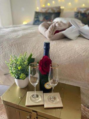 VertonLOVER'S ROOM TROPIC的一张带一瓶葡萄酒和两杯酒的床