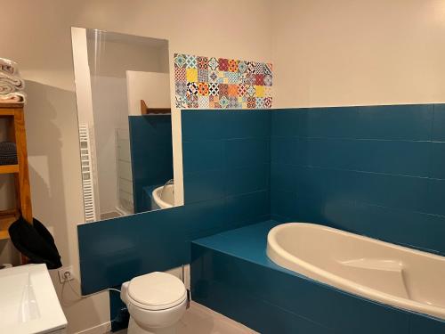 图卢兹Lbkn的蓝色的浴室设有浴缸、卫生间和水槽。