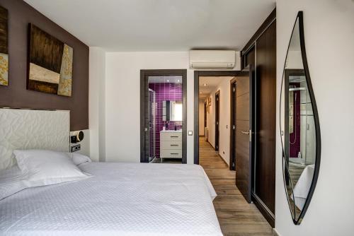 坎布里尔斯Dreams Port Cambrils Apartment的卧室配有白色的床和镜子