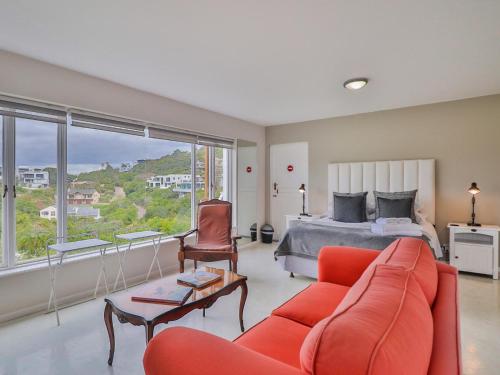 克尼斯纳Glenview Heads Apartments的客厅配有床和红色沙发