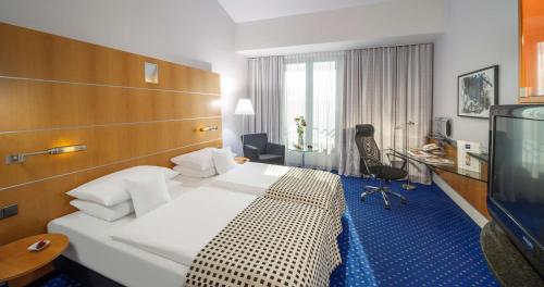 波茨坦多林特三索斯柏林/波茨坦酒店的酒店客房,配有床和电视