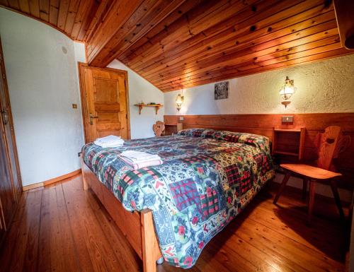 Chalet della Civetta的一间卧室设有一张床和木制天花板