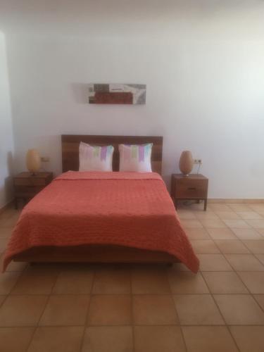 圣埃乌拉利亚Siesta el por del sol的一间卧室配有一张带红色毯子的大床