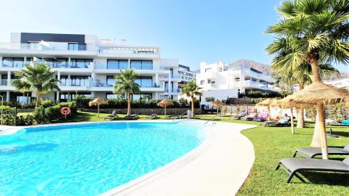 福恩吉罗拉AA Guest - Luxury Paradise Eco Apartment Higueron的一座大建筑前的游泳池