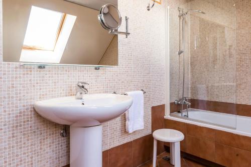帕斯底拉卡萨Hotel Grand Pas的浴室配有盥洗盆、镜子和浴缸